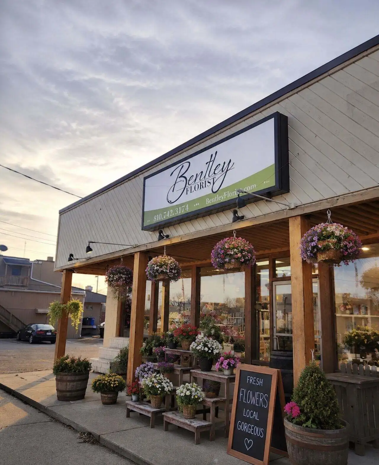 The Bentley Florist storefront in Burton, Michigan, with hanging baskets and fresh flowers out front